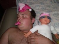 Mann mit Schnuller und Puppe
